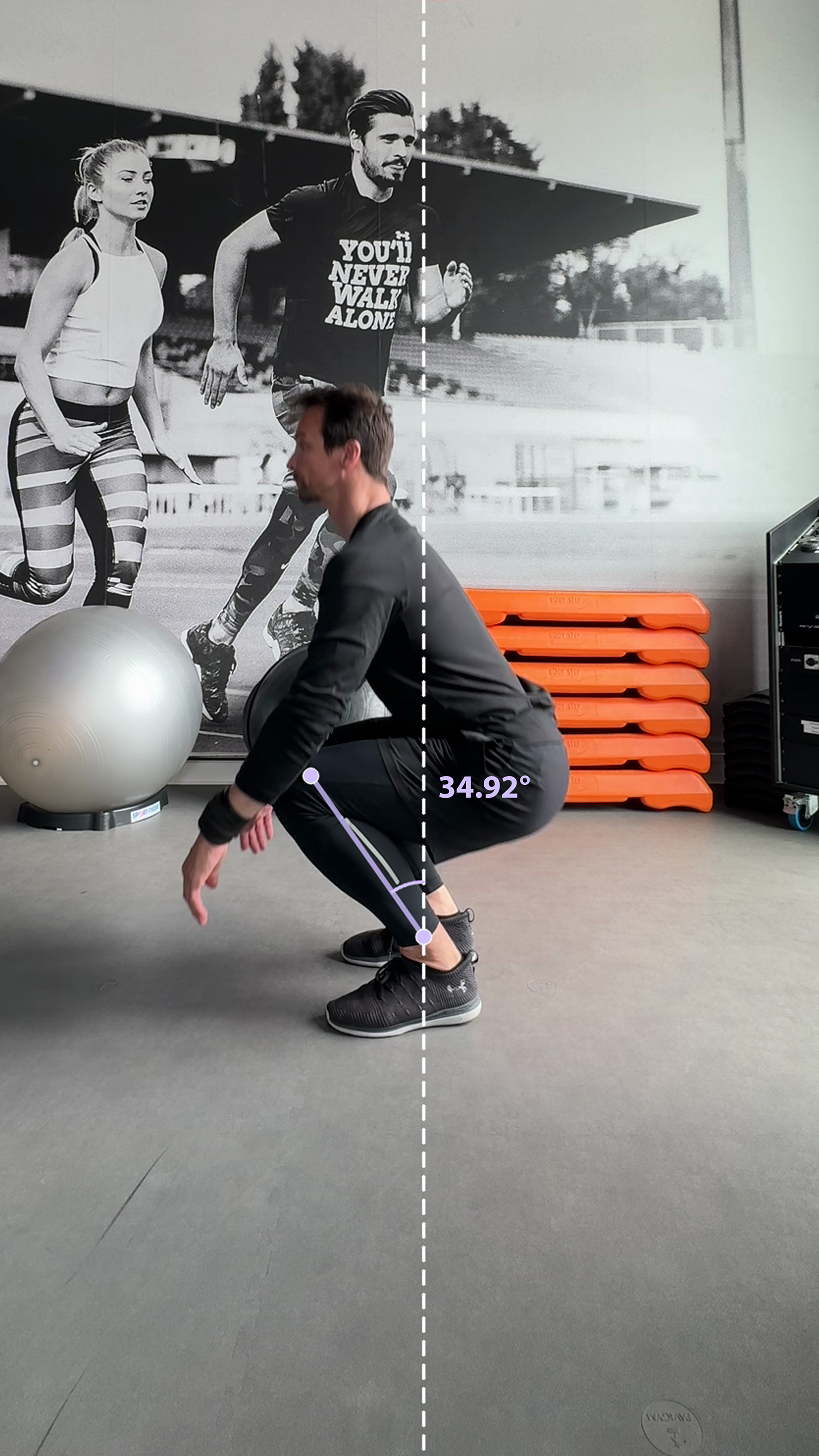 Sagittal deep squat frame showing a shin line and an angle of 34.92 degrees measured from the dashed image vertical.