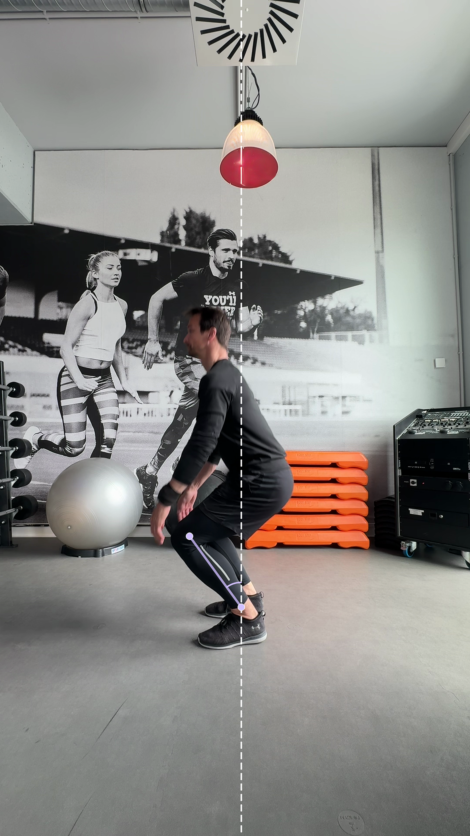 User-facing view of tibia inclination at approximately 90 degrees of knee flexion during squat descent, showing the shin and its angle relative to vertical without engineering annotations.